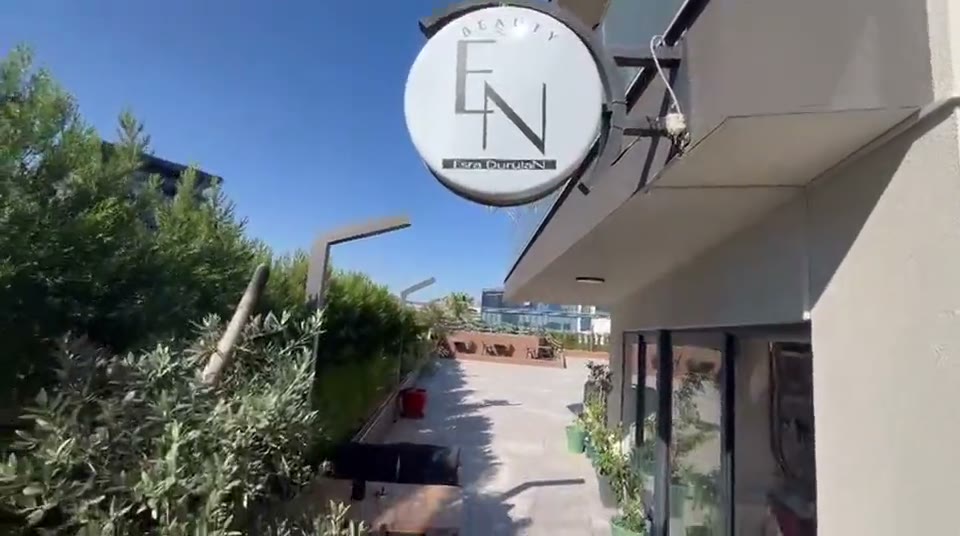 Sokaktan görünen EN Beauty Studio tabelası, altında zeytin ağaçlı teras ve giriş kapısı